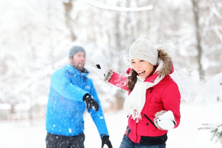 young couple having snowball fight